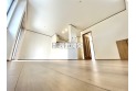 【居間】リビングは白を基調とし床材は木目調の落ち着いた色合いになっております。